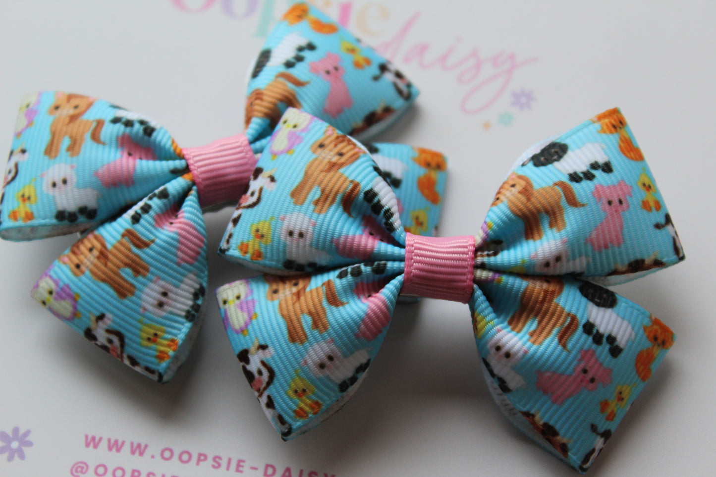 Colorful hair bows with animal patterns on a light blue background.