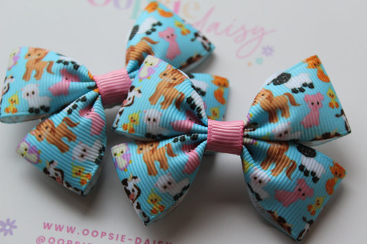 Colorful hair bows with animal patterns on a light blue background.