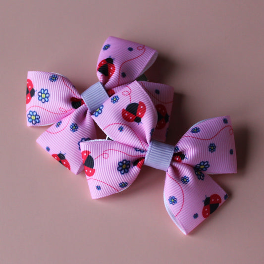 Pink hair bows with red ladybirds and tiny purple flowers