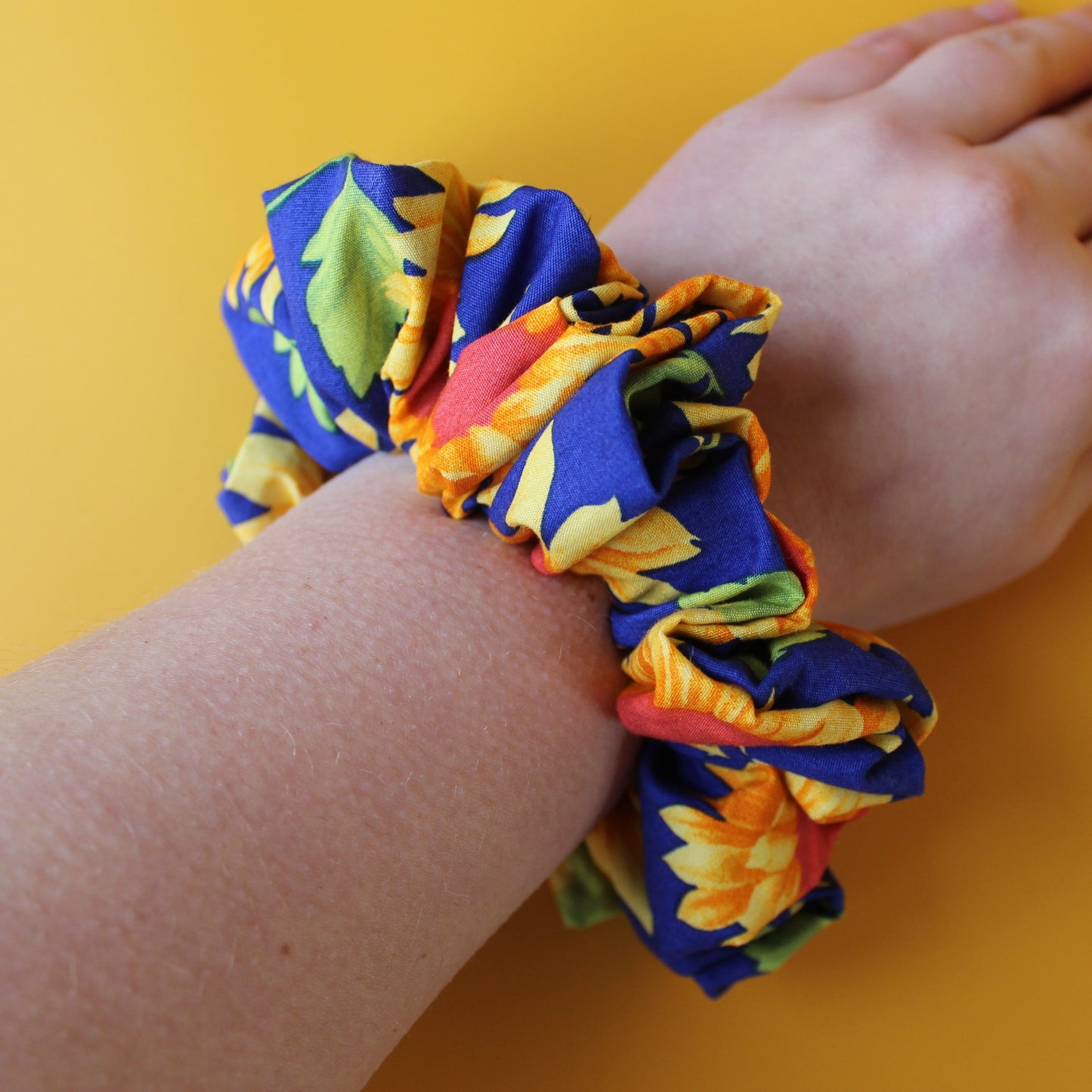 Oversized blue scrunchie with bold yellow and orange sunflowers