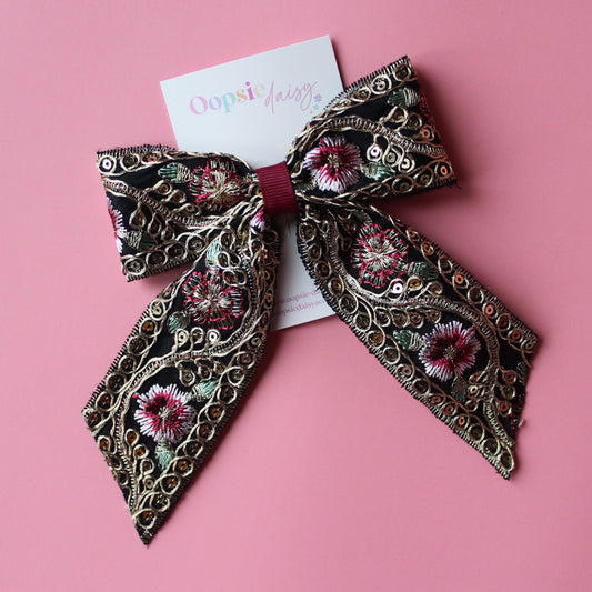 Black hair bow with gold and burgundy embroidered floral pattern