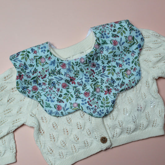 Blue scallop baby bib with ditsy floral pattern