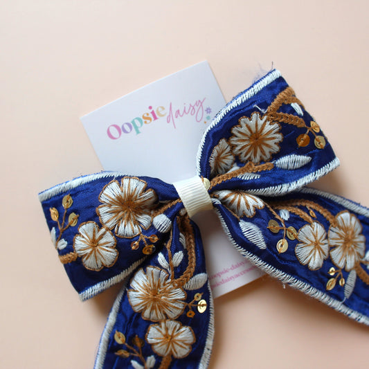 Blue and white embroidered hair bow with floral pattern
