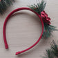 Red headband with green foliage and festive red rose