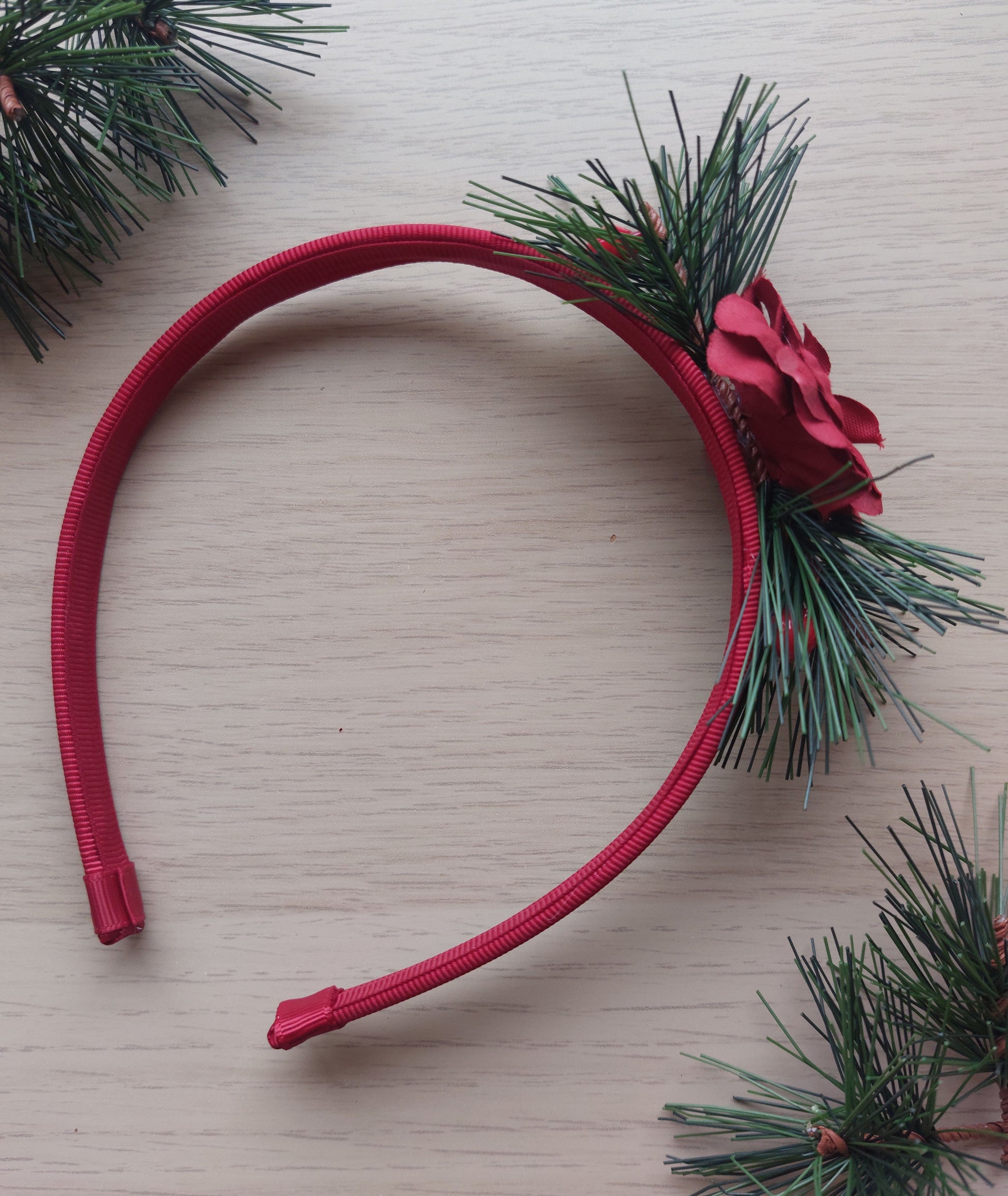 Red headband with green foliage and festive red rose