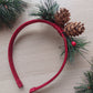 Red festive headband with pine cones and green foliage