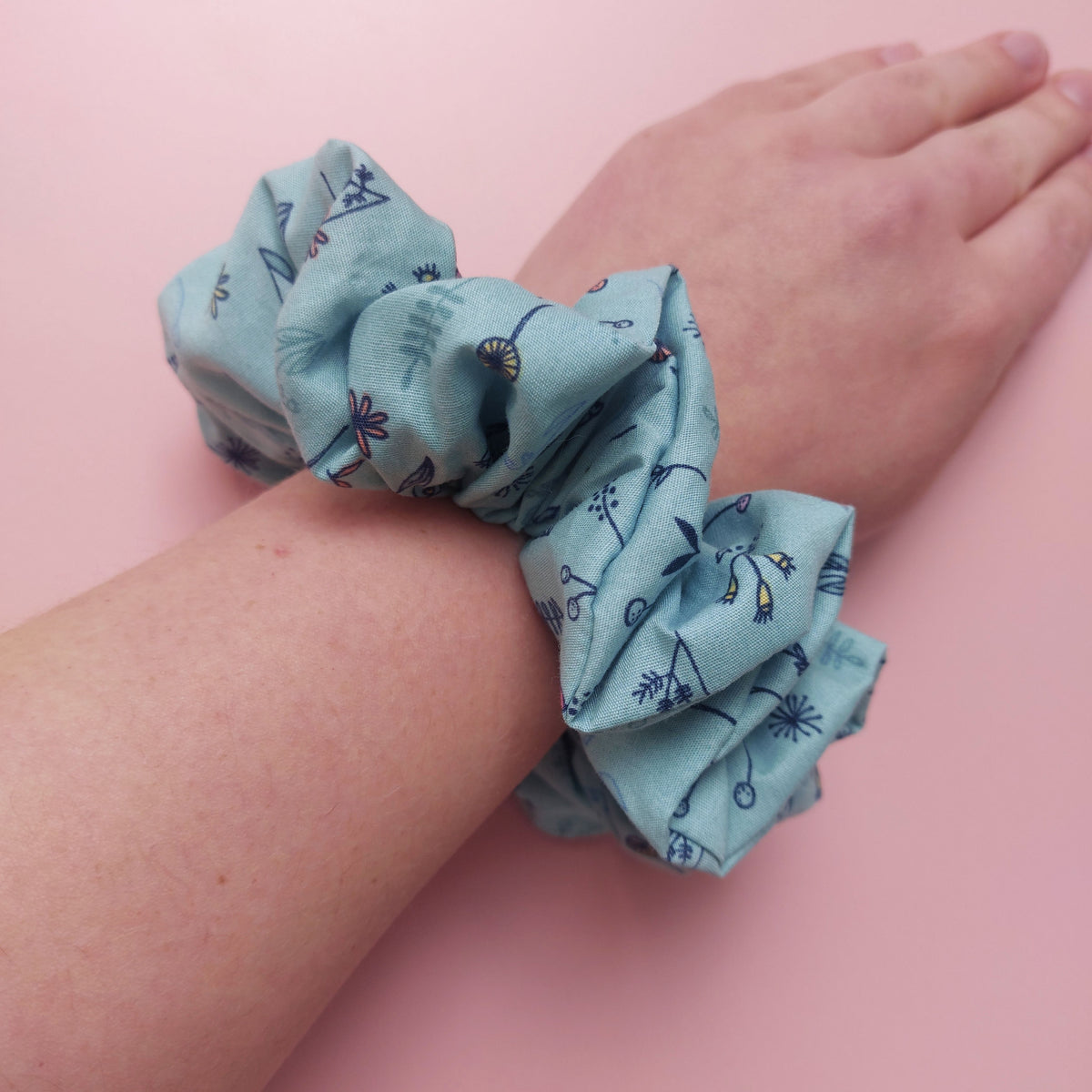 Oversized scrunchie with botanical floral pattern on a light blueish-green background