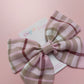 Light pink tartan hair bow with beige, white and burgundy checks. 