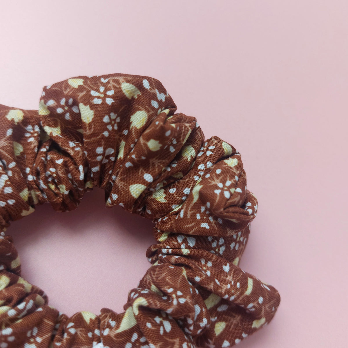 Warm brown scrunchie with small cream floral print. 
