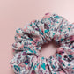 Oversized scrunchie in white with paisley floral pattern in pink and turquoise. 