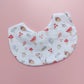 White round shaped baby bib with autumnal pattern of mushrooms, acorns, leaves and autumn flowers. 