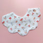 Scallop edged baby bib in white with autumnal pattern. Featuring mushrooms, acorns, leaves and autumnal flowers. 