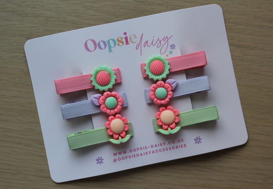 Set of colourful hair clips with 3D floral embellishment. 