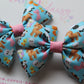Colorful hair bows with animal patterns on a light blue background.