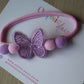 Pink hairband with butterfly and pom-poms