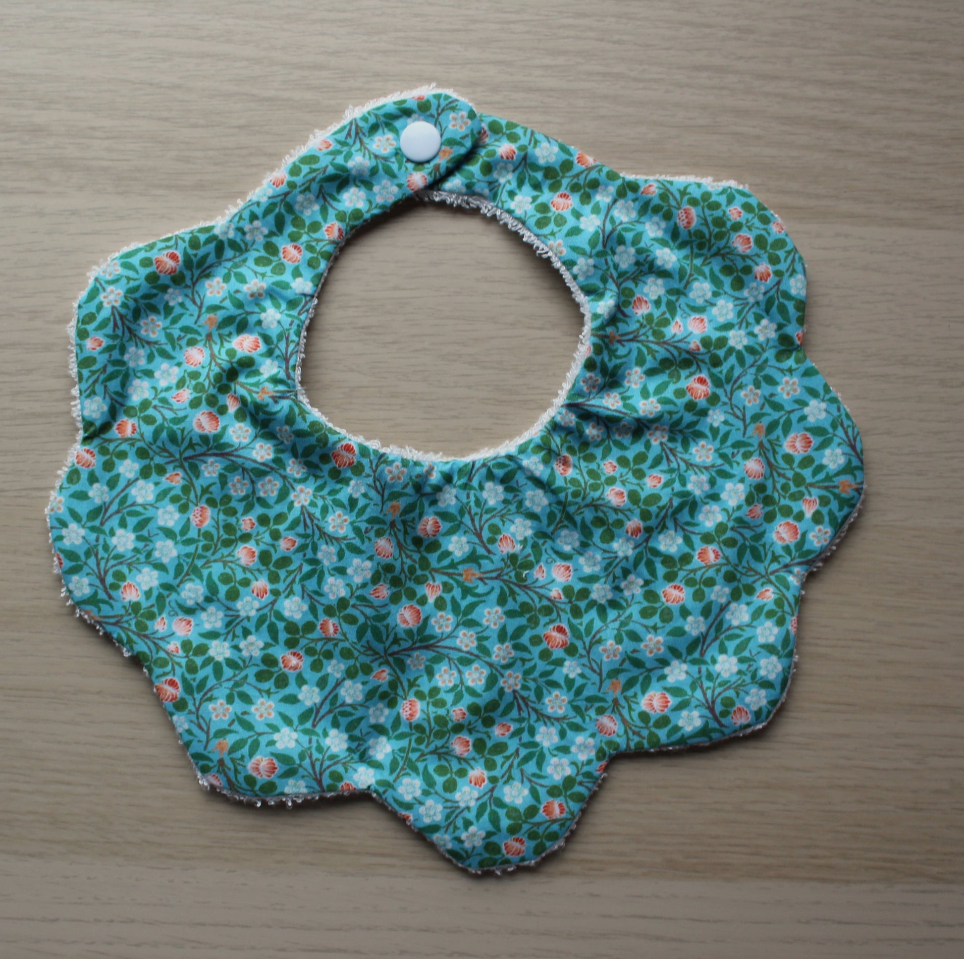 Baby bib with scallop shape and ditsy flowers