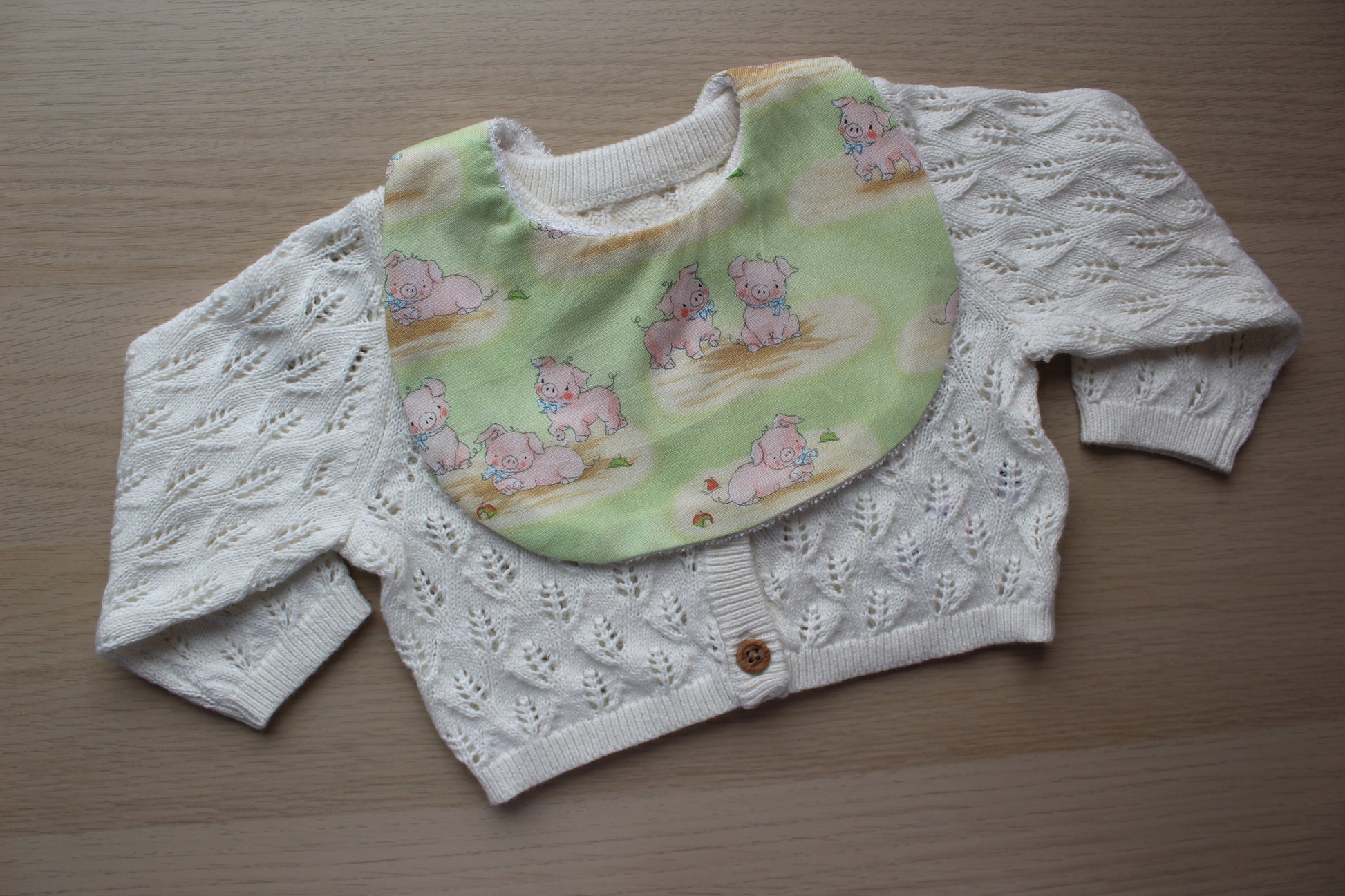 Rounded baby bib with cute little pig design