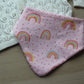Pink dribble baby bib with rainbow polka dot design