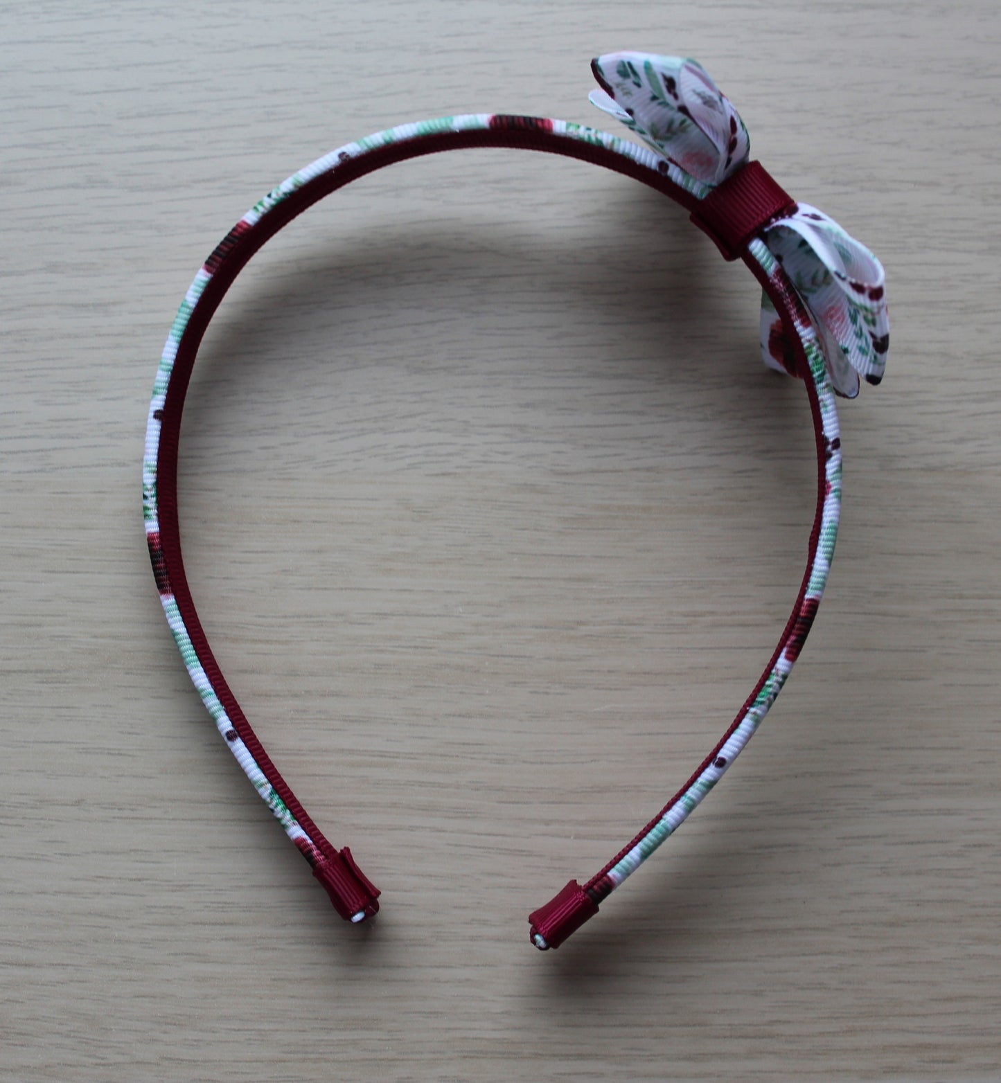 Headband with burgundy floral design and bow