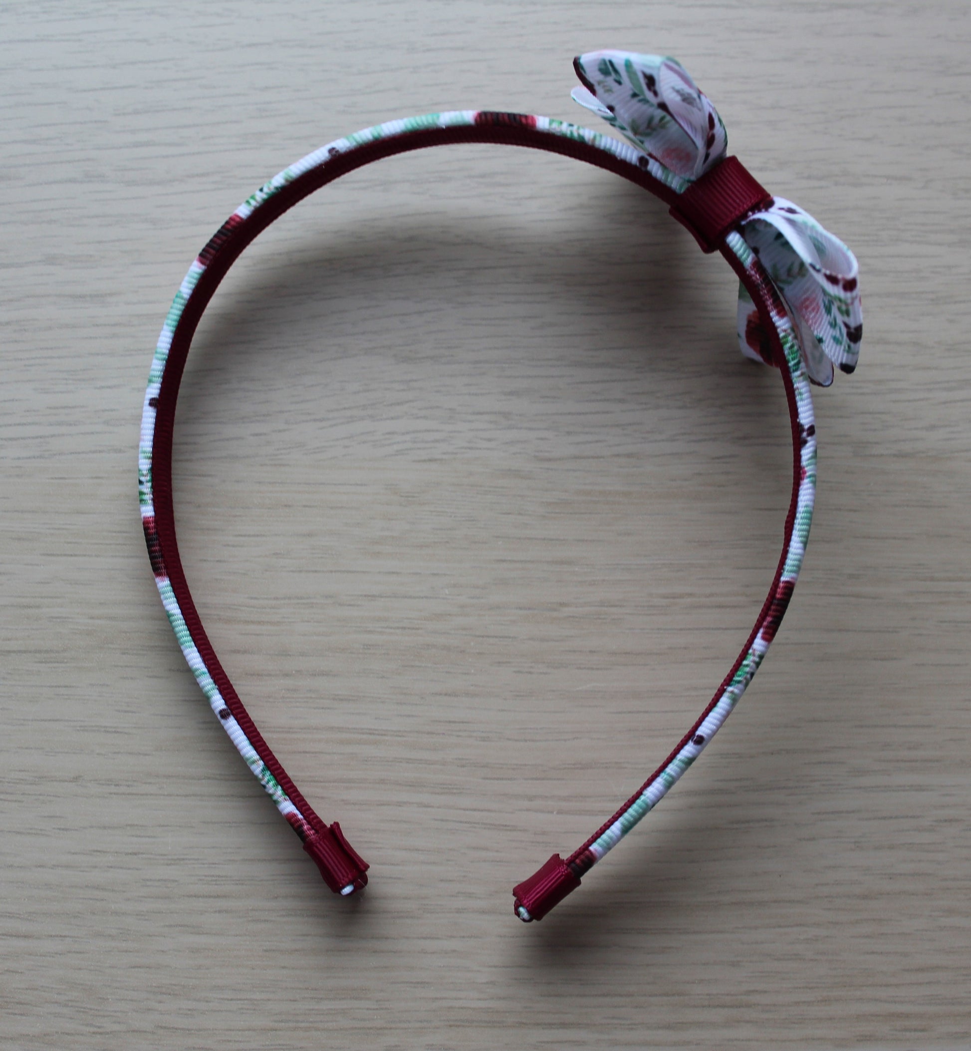 Headband with burgundy floral design and bow