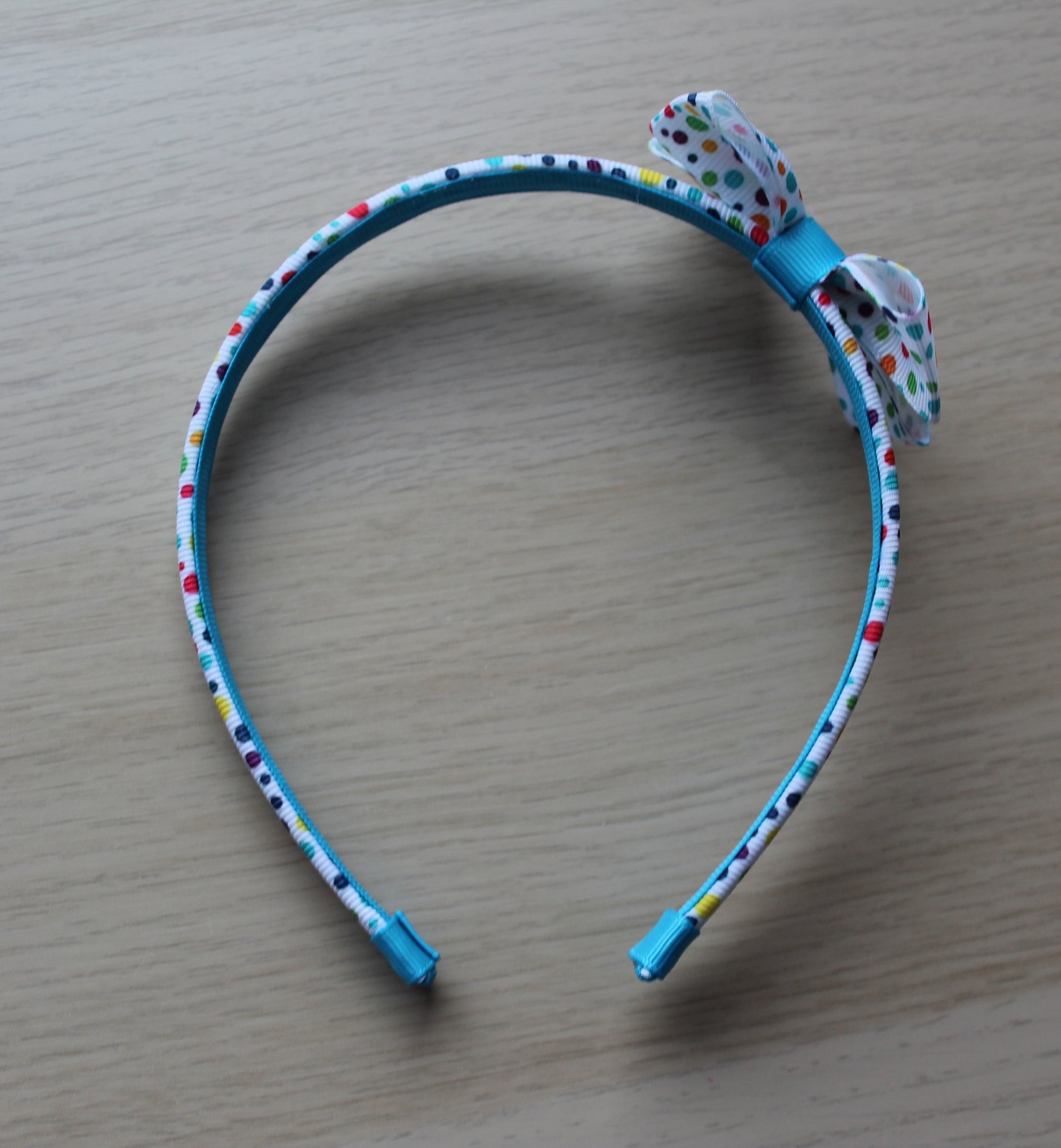 Headband features a polka dot pattern and bow