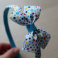 Colorful polka dot bow on a blue and polka headband