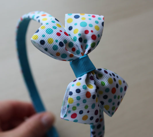 Colorful polka dot bow on a blue and polka headband