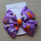 Halloween-themed purple bow with pumpkins, ghosts, and bats 