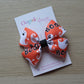 Orange and white Halloween-themed bow with ghosts