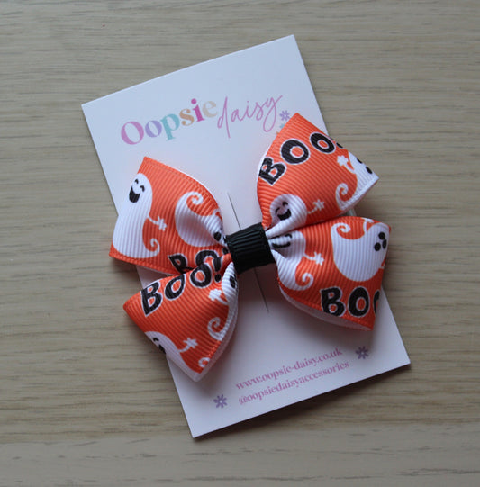 Orange and white Halloween-themed bow with ghosts