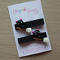 Black hair clips with halloween themed cat on a broomstick
