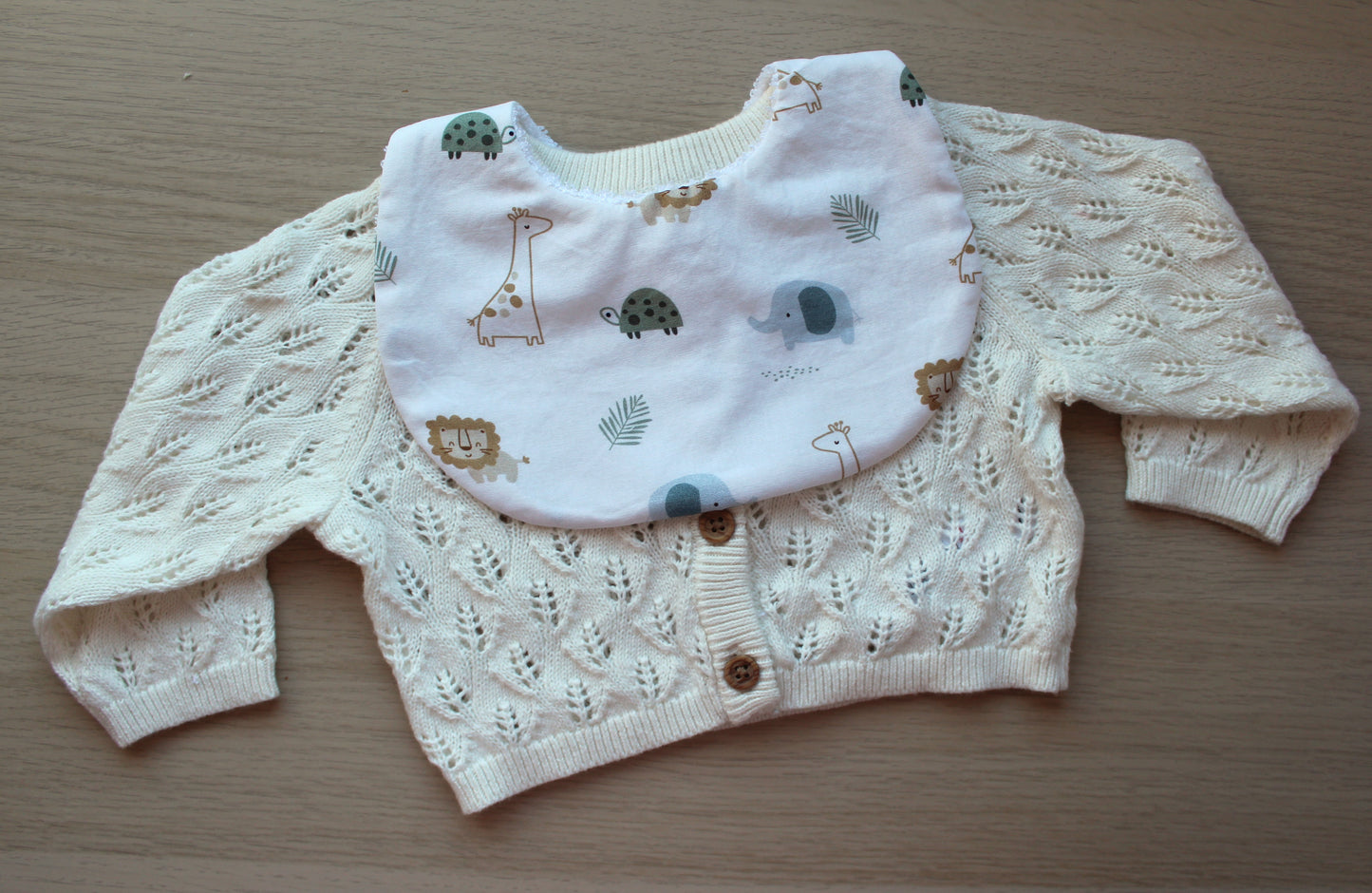 White baby bib with neutral baby animal design