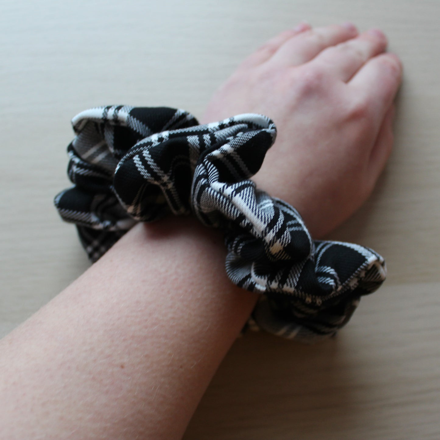 Oversized black and white tartan plaid hair scrunchie on wrist