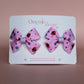 Pink hair bows with red ladybirds and tiny purple flowers