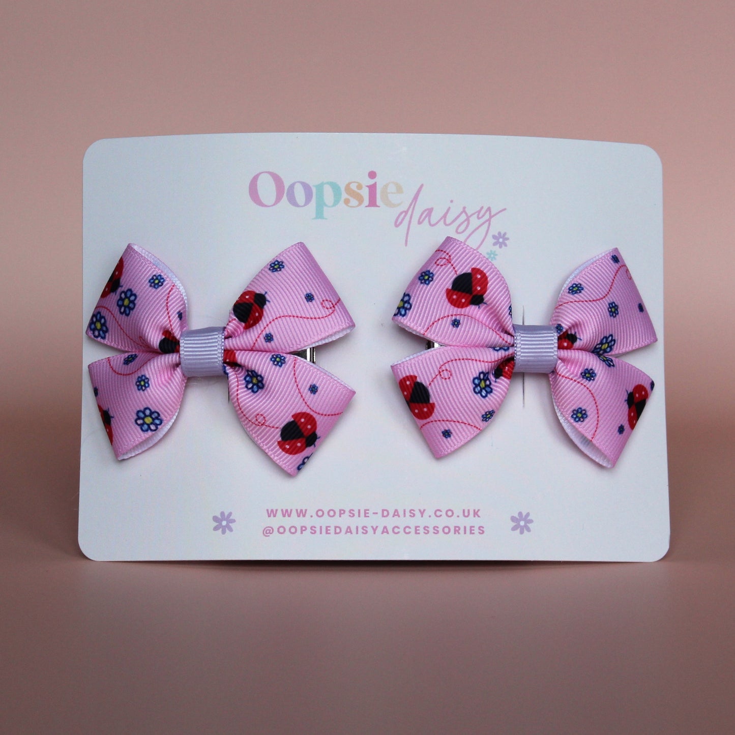 Pink hair bows with red ladybirds and tiny purple flowers