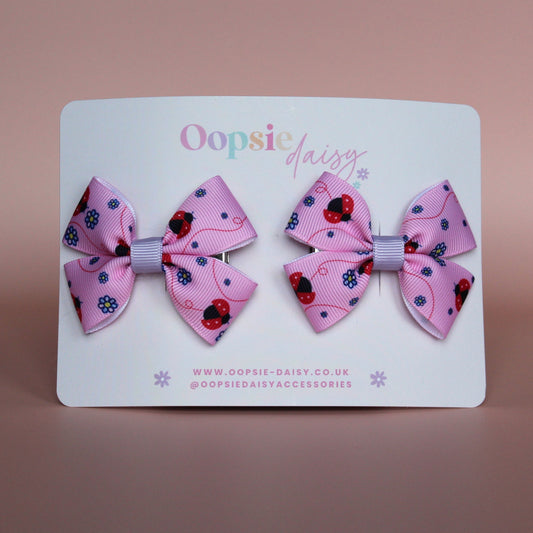 Pink hair bows with red ladybirds and tiny purple flowers