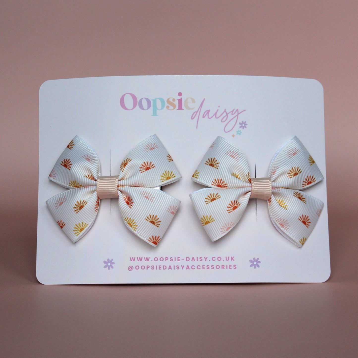 Cream hair bows with subtle orange, pink and yellow little sun pattern