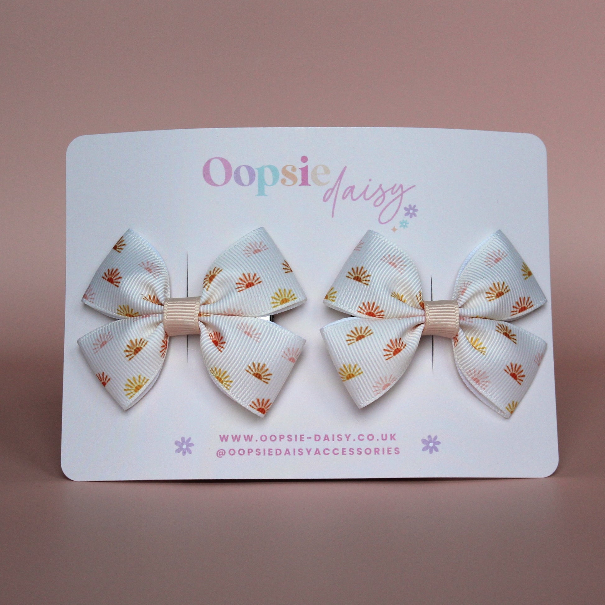 Cream hair bows with subtle orange, pink and yellow little sun pattern