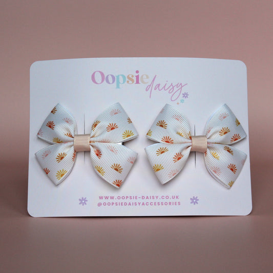 Cream hair bows with subtle orange, pink and yellow little sun pattern