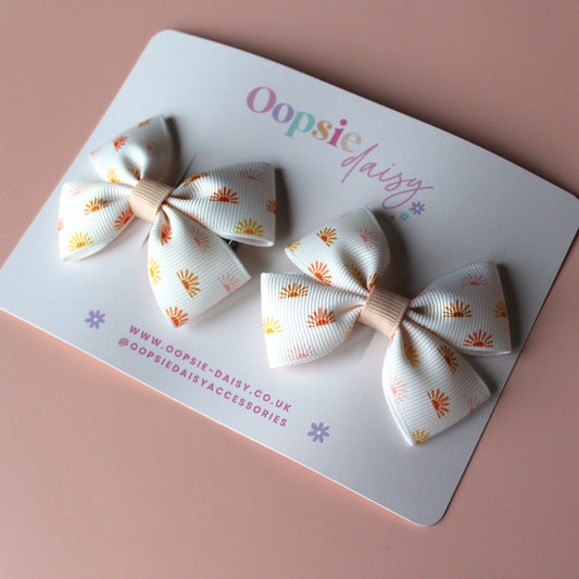 Cream hair bows with subtle orange, pink and yellow little sun pattern