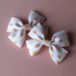 Cream hair bows with subtle orange, pink and yellow little sun pattern