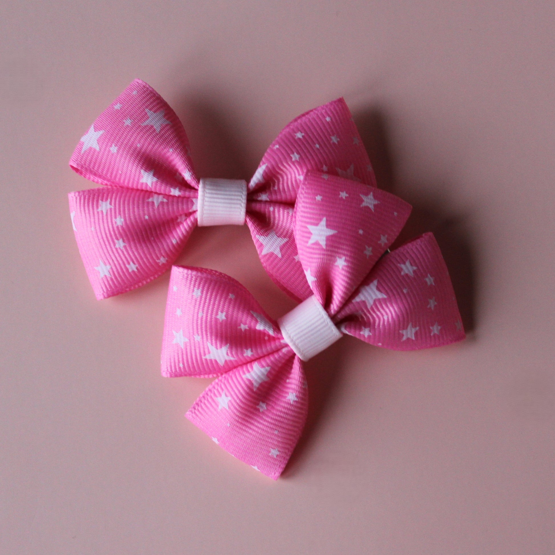 Pair hair bows in pink with small white stars