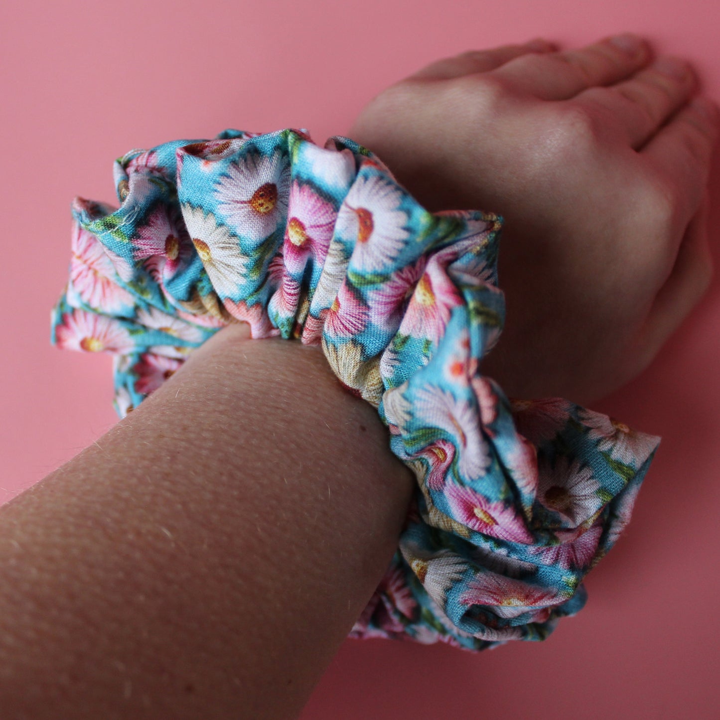 Blue and pink daisy floral patterned oversized hair scrunchie on wrist