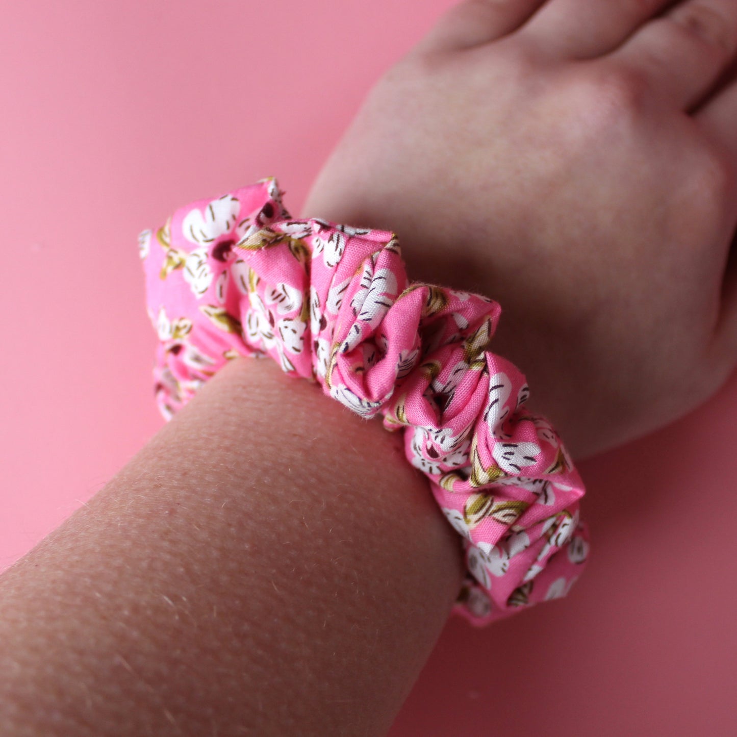 Pink floral hair scrunchie on wrist