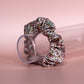 Floral patterned hair scrunchie in pink with white, yellow and green all over pattern. 