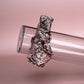 Floral patterned hair scrunchie in pink with white, yellow and green all over pattern. 