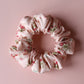 Pale pink scrunchie with subtle red small flowers