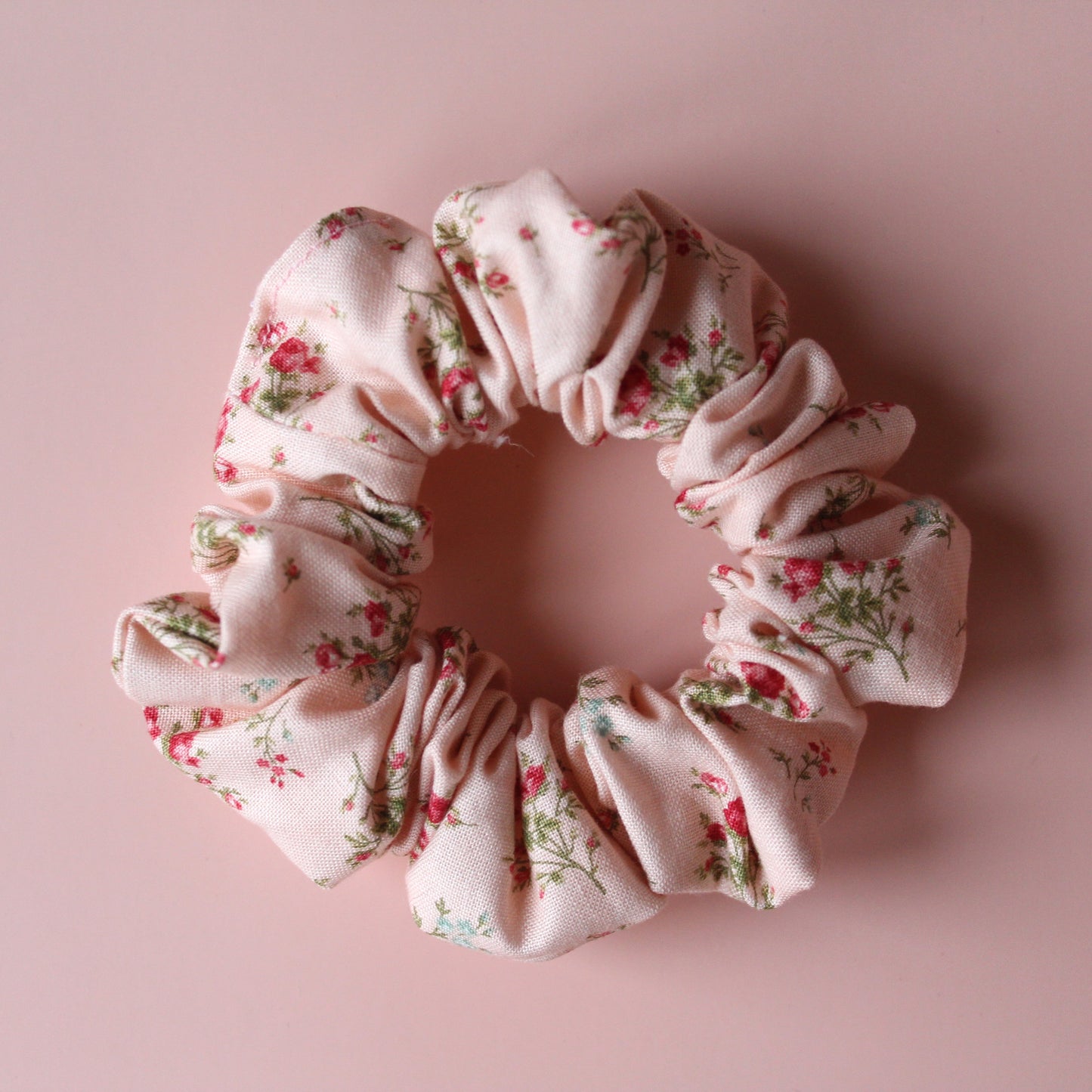 Pale pink scrunchie with subtle red small flowers