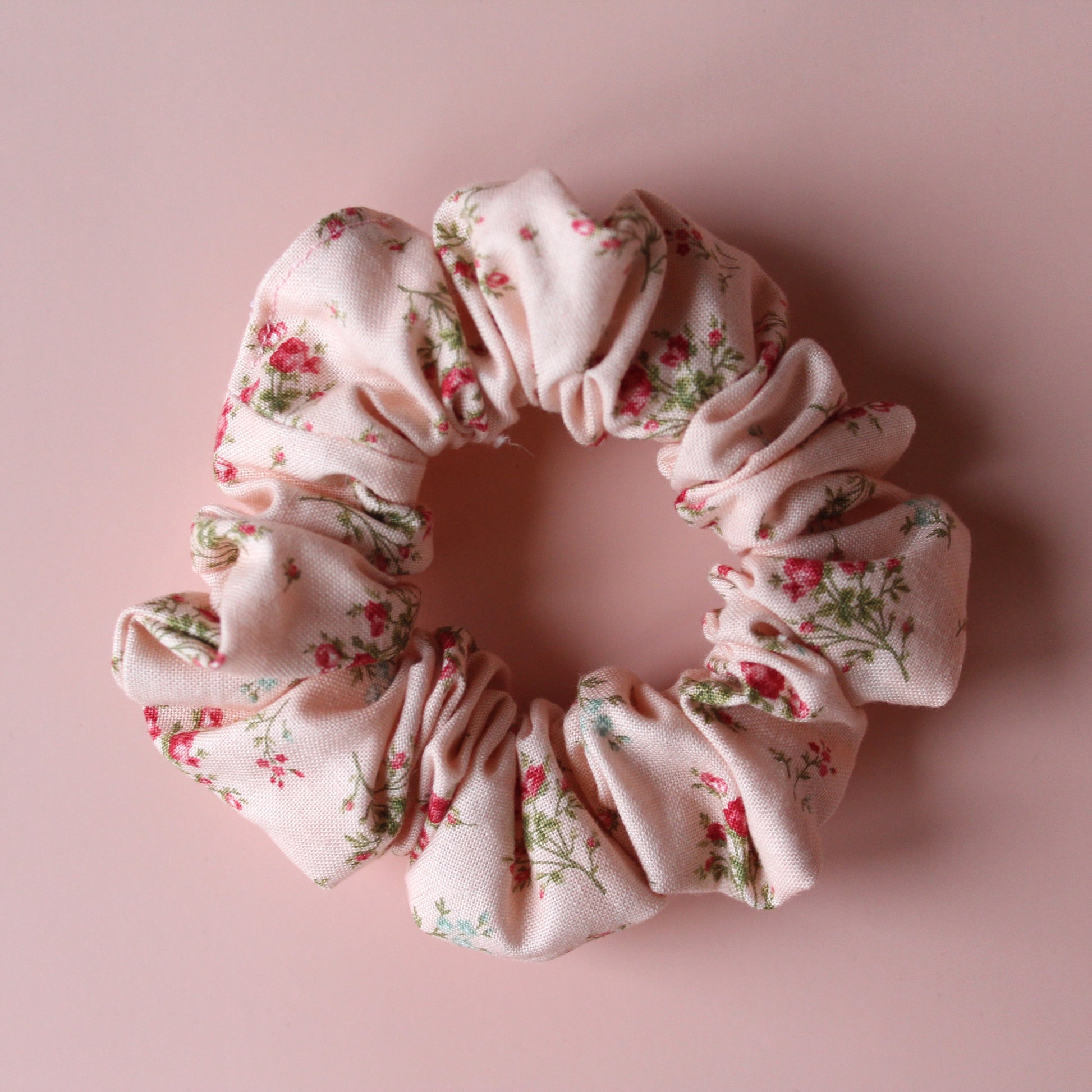 Pale pink scrunchie with subtle red small flowers