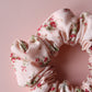Pale pink scrunchie with subtle red small flowers
